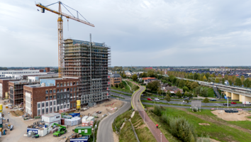 Werkzaamheden woningbouw fietsbrug hijskraan flat appartementencomplex